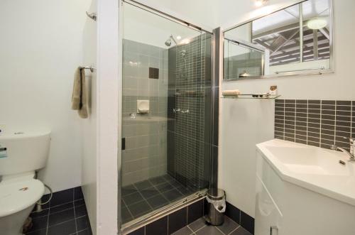 a bathroom with a shower, sink, and toilet at Biloela Countryman Motel in Biloela