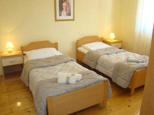 two beds in a small room with two lamps at Apartman Poldrugovac in Labin