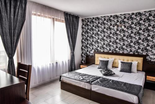 a bedroom with a bed and a table and a window at Dimitur Jekov Guest House in Obzor