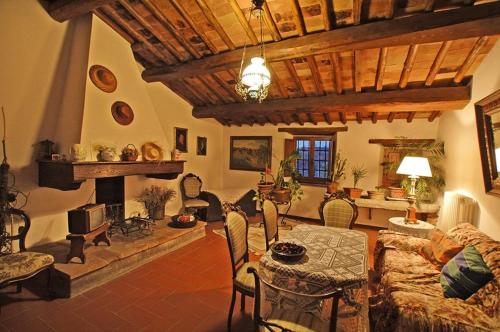 ein Wohnzimmer mit einem Tisch und einem Kamin in der Unterkunft Albergo Il Colombaio in Castellina in Chianti