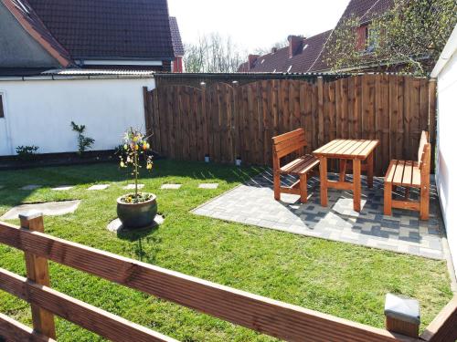 une cour avec une table, deux chaises et une clôture en bois dans l'établissement Fischerhaus Bremerhaven, à Bremerhaven