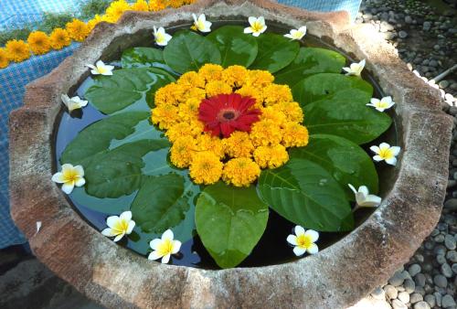 a flower pot with yellow and red flowers in it at Amed Cafe & Hotel Kebun Wayan in Amed