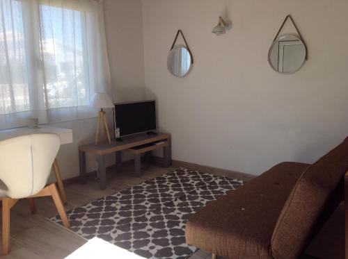 ein Wohnzimmer mit einem Sofa und einem TV in der Unterkunft Chalet Marivent in Cala'n Bosch