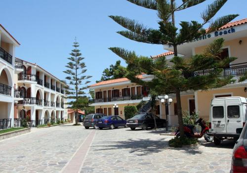 a street with cars parked in front of buildings at Castello Beach Hotel in Argasi
