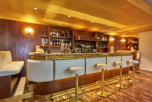 a bar in a restaurant with stools in a room at Hotel Capri in Malcesine