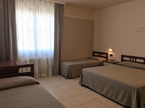 een hotelkamer met 2 bedden en een raam bij Hotel Euro in San Giovanni Rotondo