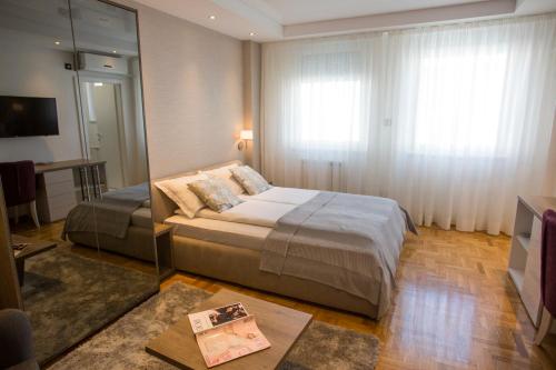 a bedroom with a large bed and a mirror at Dia Belgrade Arena Apartment in Belgrade