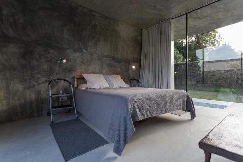 a bedroom with a bed and a large window at Villa Refuge Astrolabe in Rabo de Peixe