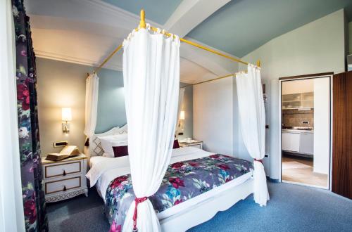 1 dormitorio con 1 cama con dosel en Villa Bellevue Portoroz-Portorose en Portorož