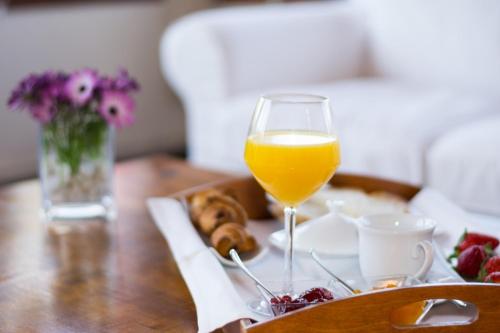 a table with a glass of orange juice and a tray of food at Hotel Masia La Palma in Espinavesa