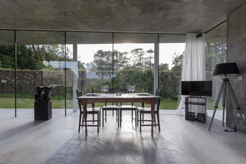 a dining room with a table and chairs and a television at Villa Refuge Astrolabe in Rabo de Peixe