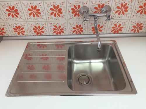 einem Spülbecken aus Edelstahl mit einem Wasserhahn in der Küche in der Unterkunft Casa Angela in Locarno