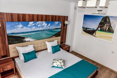 a bedroom with a bed with a picture on the wall at Stela Apartments in Obzor