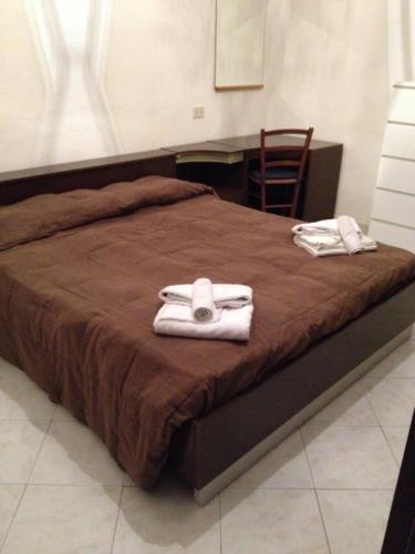 a bed with two towels on top of it at Foscolomare in Viareggio