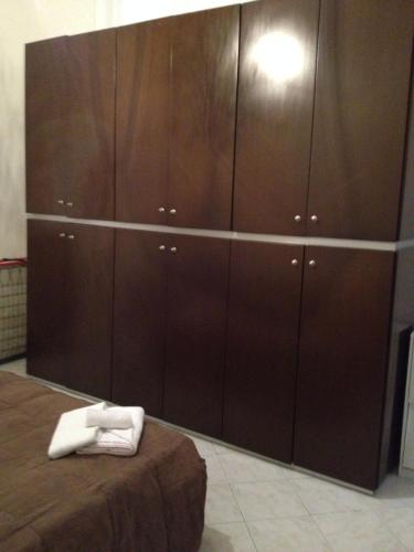 a bedroom with brown cabinets with white towels on a bed at Foscolomare in Viareggio