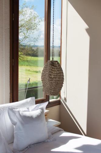 a bedroom with a bed and a window with a chandelier at Hotel Masia La Palma in Espinavesa