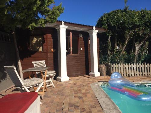 a small house with a swimming pool and a toy at Leo's Den in Fish hoek