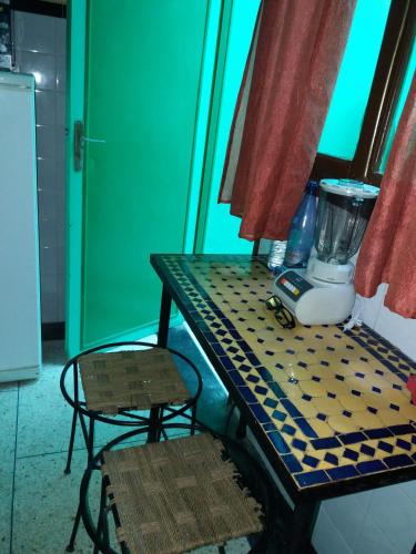 a table with a blender and a chair on it at Chez Pascal et Nicole in Oualidia