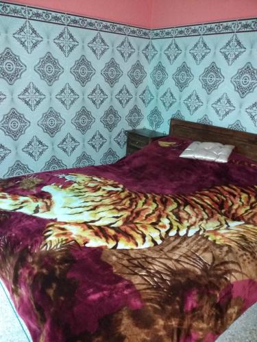 - un lit avec une couverture violette et un mur dans l'établissement Chez Pascal et Nicole, à Oualidia