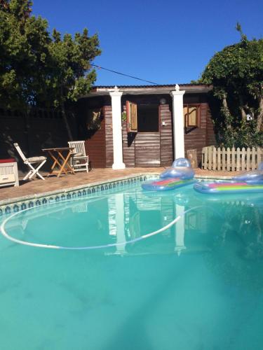 a swimming pool with two slides in it at Leo's Den in Fish hoek