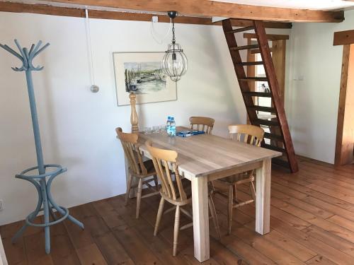 a dining room with a wooden table and chairs at Heerlijk Dijkhuisje in Paal in Graauw