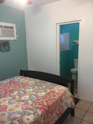 a bedroom with a bed and a bathroom with a toilet at Palmetto Guesthouse in Culebra