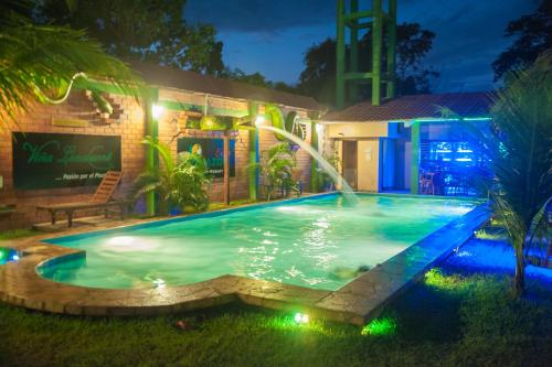 a swimming pool with a fountain in front of a building at Amazon City in Pucallpa
