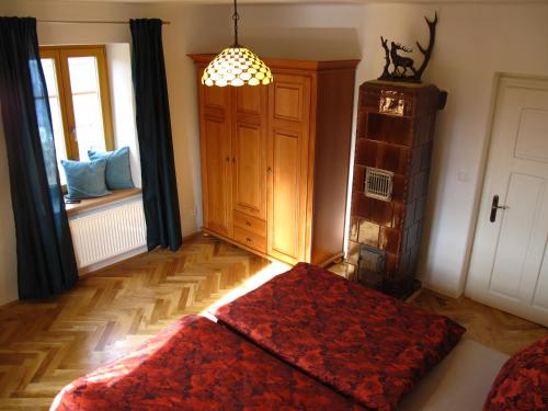 a bedroom with a bed with a red rug and a window at Apartmány na hájovně in Jeseník