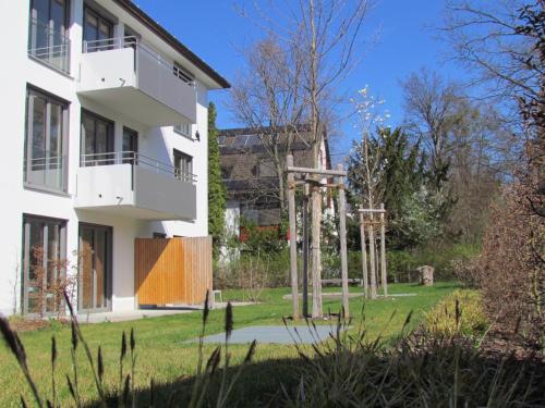 a building with columns in a yard next to a building at AMENITY-Garden-Apartments in Munich