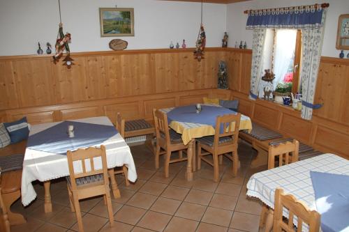 uma sala de jantar com duas mesas e cadeiras em Pension Mühlbauer em Lam