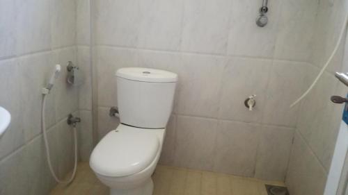 a bathroom with a white toilet and a sink at Homely Guest in Habarana