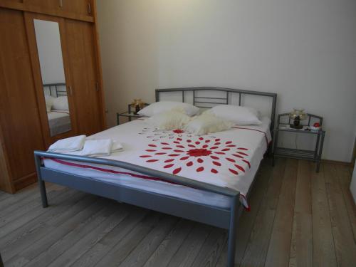 a bedroom with a large bed with red flowers on it at Apartment Antonio in Šibenik