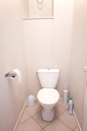 - une salle de bains blanche avec des toilettes et un rouleau de papier toilette dans l'établissement Ocean Apartment, à Saint-Malo