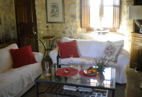 a living room with two white couches and a table at Stone House in a quiet landscape, Leonidion in Leonidion