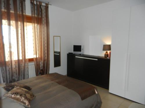 a bedroom with a bed and a dresser and a television at Casa Domenica - 200m dal mare in Ceriale