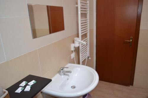 a bathroom with a white sink and a mirror at B&B Il Vicoletto in LʼAquila