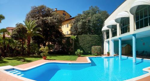 a large blue swimming pool in front of a building at Hotel Settentrionale Esplanade in Montecatini Terme