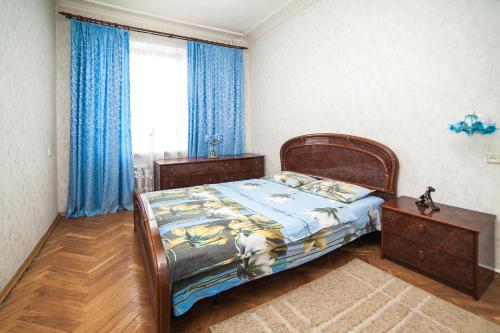 a bedroom with a bed and a window with blue curtains at VipArenda Minsk 1 in Minsk