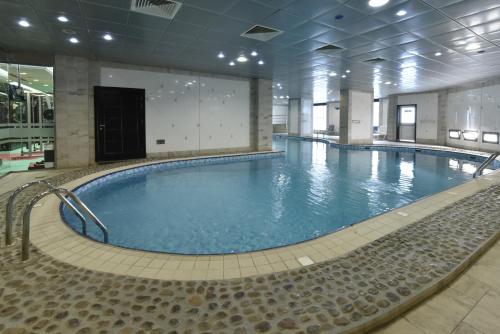 - une grande piscine dans un grand bâtiment dans l'établissement Awaliv International Hotel, à Taif