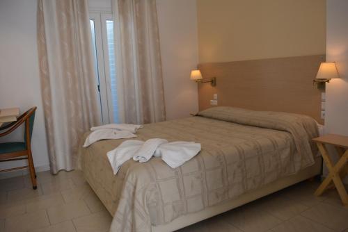 a bedroom with a bed with towels on it at Anemomilos Villa in Firostefani