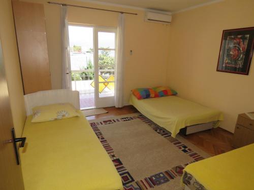 um quarto com duas camas e uma porta para uma varanda em Rooms Beba em Herceg Novi
