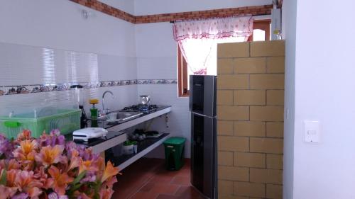 a small kitchen with a sink and a refrigerator at Apartahotel La Gran Familia in Villa de Leyva