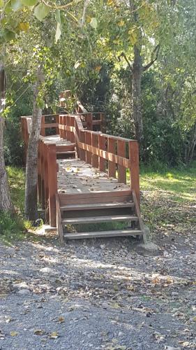 a wooden bridge in a park next to a tree at Vientos de Chauquen in Panguipulli