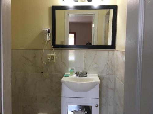 y baño con lavabo y espejo. en Americas Best Value Inn Ozona en Ozona