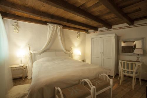 a bedroom with a white bed and a chair at Casa Vecia in Brtonigla