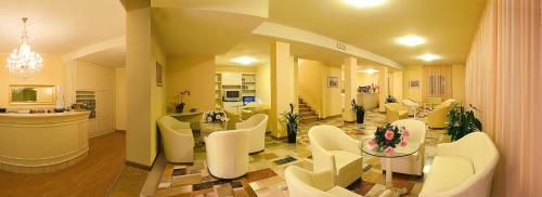 sala de estar con sillas blancas y mesa en Hotel Plaza, en Gabicce Mare