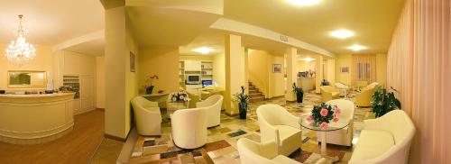 a living room with white chairs and a table at Hotel Plaza in Gabicce Mare