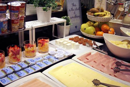 a buffet with fruit and other food on a table at Hotel Conde Duque Bilbao in Bilbao