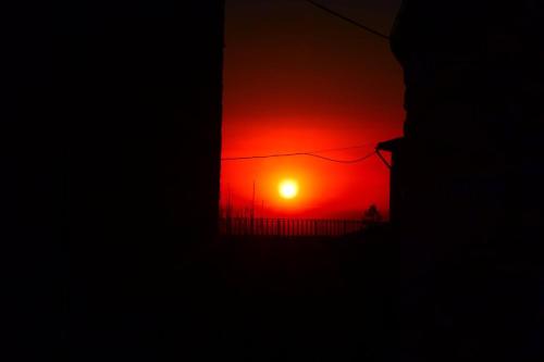 a sunset seen through a window of a building at Apartments Aurora Delle Rose in Assisi