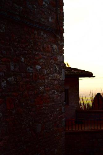 a brick building with the sunset in the background at Apartments Aurora Delle Rose in Assisi